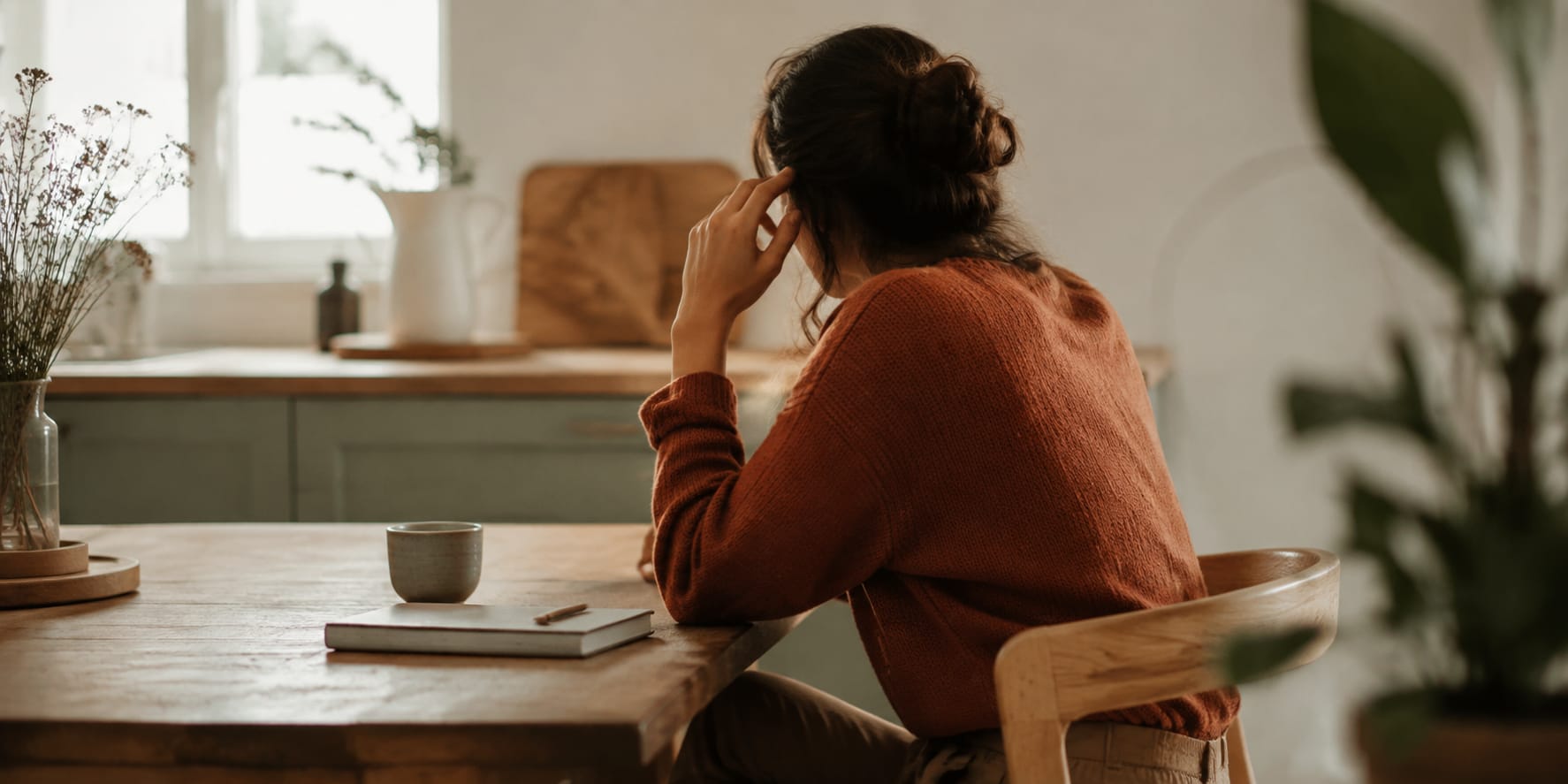 Illustration du stress quotidien : une personne assise à sa table, la main près de la tempe.